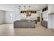 Modern kitchen with a large island, pendant lighting, and white and gray cabinets at 14687 N 73Rd Dr, Peoria, AZ 85381