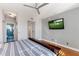 Bright bedroom with hardwood floors, en suite bathroom, and golf on television at 15221 N Clubgate Dr # 2059, Scottsdale, AZ 85254