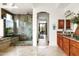 Modern bathroom with decorative tile shower, double sink with natural wood cabinets, and backyard access at 15816 E Eagle Crest Rd, Fountain Hills, AZ 85268