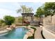 An exquisite backyard features a custom pool, spa, pergola, and lush landscaping for ultimate relaxation and entertainment at 15816 E Eagle Crest Rd, Fountain Hills, AZ 85268