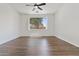 Spacious bedroom with hardwood floors, a ceiling fan, and a bright window offering natural light at 15959 W Hearn Rd, Surprise, AZ 85379