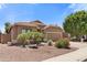 Charming single-story home with a desert landscape, featuring palm trees and a tile roof at 15959 W Hearn Rd, Surprise, AZ 85379