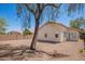 The backyard features a desert landscape, block wall, and mature trees at 1608 S 82Nd Dr, Phoenix, AZ 85043