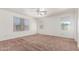 Neutral bedroom with plush carpet, multiple windows, and a ceiling fan at 1608 S 82Nd Dr, Phoenix, AZ 85043