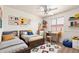 bedroom featuring twin beds, a ceiling fan, a desk, and colorful decor at 1608 S 82Nd Dr, Phoenix, AZ 85043