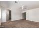 Spacious bedroom with plush carpet, ceiling fan, and en-suite bathroom access at 1608 S 82Nd Dr, Phoenix, AZ 85043