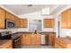 Functional kitchen with oak cabinets, stainless steel appliances, and a tile backsplash at 1608 S 82Nd Dr, Phoenix, AZ 85043