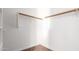 Clean walk-in closet with carpeted floor and wooden clothing rods and shelving at 1608 S 82Nd Dr, Phoenix, AZ 85043