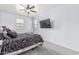 Bright primary bedroom featuring a ceiling fan and a mounted television at 1733 N 77Th Dr, Phoenix, AZ 85035