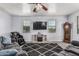 Bright living room with dark area rug, television, fireplace and a comfortable massage chair at 1733 N 77Th Dr, Phoenix, AZ 85035