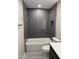 Bathroom with updated grey subway tile shower and white tub at 1813 E Boise St, Mesa, AZ 85203