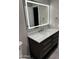 Bathroom vanity with dark wood cabinets, gray walls, and a modern, illuminated mirror for a sleek design at 1813 E Boise St, Mesa, AZ 85203