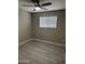 Neutral bedroom features wood-look floors, ceiling fan, and a window at 1813 E Boise St, Mesa, AZ 85203
