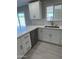 Bright kitchen featuring white cabinets, quartz countertops, stainless steel appliances, and sliding doors to backyard at 1813 E Boise St, Mesa, AZ 85203