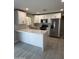 Bright kitchen featuring white cabinetry, stainless steel appliances, and a peninsula counter at 1813 E Boise St, Mesa, AZ 85203