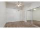 Bright bedroom featuring a lighted ceiling fan, neutral carpeting, a closet, and a white door at 1836 N Stapley Dr # 191, Mesa, AZ 85203