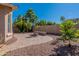 Well maintained backyard featuring desert landscaping, mature trees and a brick firepit at 20557 W Lost Creek Dr, Buckeye, AZ 85396