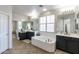 Well-lit bathroom with double sinks, soaking tub, and a separate vanity area at 20557 W Lost Creek Dr, Buckeye, AZ 85396