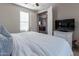 Serene bedroom with a ceiling fan, plush bedding, and a view into the living area, creating a relaxing atmosphere at 20557 W Lost Creek Dr, Buckeye, AZ 85396