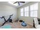 Exercise room with Peloton bike, ceiling fan, and windows providing natural light at 20557 W Lost Creek Dr, Buckeye, AZ 85396