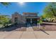 Charming two-story home with a welcoming front porch and desert landscaping under a bright blue sky at 20557 W Lost Creek Dr, Buckeye, AZ 85396