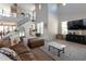 Spacious living room with soaring ceilings, a staircase, large windows, and stylish furnishings at 20557 W Lost Creek Dr, Buckeye, AZ 85396