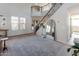 Bright living room with high ceilings, decorative rug, staircase, and a view to the living area at 20557 W Lost Creek Dr, Buckeye, AZ 85396
