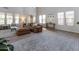 Bright, open living room featuring a sectional sofa, large windows, and stylish decor at 20557 W Lost Creek Dr, Buckeye, AZ 85396