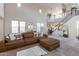 Bright living room with a view of the staircase and balcony, a large sofa, and ample natural light at 20557 W Lost Creek Dr, Buckeye, AZ 85396