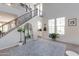 Spacious living room featuring a staircase, high ceilings, and large windows that offer plenty of natural light at 20557 W Lost Creek Dr, Buckeye, AZ 85396