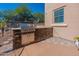 Outdoor kitchen features a built-in grill, stone accents and a paved patio area at 20557 W Lost Creek Dr, Buckeye, AZ 85396