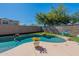 Backyard swimming pool with desert landscaping, mature trees and artificial turf at 20557 W Lost Creek Dr, Buckeye, AZ 85396