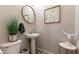 Charming powder room with a pedestal sink, decorative mirror, and stylish accents create a warm and inviting space at 20557 W Lost Creek Dr, Buckeye, AZ 85396