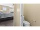 Hallway view into a bathroom featuring a standard toilet and bedroom in the distance at 2111 N 77Th Gln, Phoenix, AZ 85035