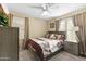 Well-lit bedroom with a comfortable queen-size bed, soft carpeting, and natural light at 2111 N 77Th Gln, Phoenix, AZ 85035