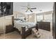 Cozy bedroom with a wooden bed frame, ceiling fan, and coordinated nightstands and dresser at 2111 N 77Th Gln, Phoenix, AZ 85035