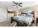 Comfortable bedroom featuring a large bed, ceiling fan, and ensuite bathroom through arched doorway at 2111 N 77Th Gln, Phoenix, AZ 85035