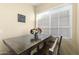 Cozy dining area boasts an inviting wooden table, chairs, and soft natural light from a large window at 2111 N 77Th Gln, Phoenix, AZ 85035