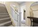 Entryway with hardwood stairs, and white banister leading to the second floor; laundry room is off to the right at 2111 N 77Th Gln, Phoenix, AZ 85035