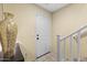 Entryway with hardwood stairs and a white front door; mosaic vase on table at 2111 N 77Th Gln, Phoenix, AZ 85035