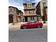 Charming three-story home with low maintenance landscaping and a red sports car parked on the street at 2111 N 77Th Gln, Phoenix, AZ 85035