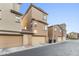 Exterior view of townhomes showcasing attached garages and neutral color palettes at 2111 N 77Th Gln, Phoenix, AZ 85035