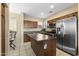 Well-lit kitchen features stainless steel appliances, an island, and tiled floors for a modern and functional space at 2111 N 77Th Gln, Phoenix, AZ 85035
