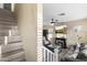 This light filled living room has a fireplace, ceiling fan, and stairs leading to the upper level at 2111 N 77Th Gln, Phoenix, AZ 85035