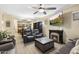 Inviting living room features a fireplace, ceiling fan, and views into the kitchen and open floor plan at 2111 N 77Th Gln, Phoenix, AZ 85035