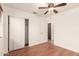 Bright bedroom features wood-look flooring, and closet with sliding doors and an open doorway to the hallway at 22615 N 31St Dr, Phoenix, AZ 85027