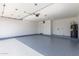 A clean garage with epoxy flooring, utility hookups, and a white door at 22615 N 31St Dr, Phoenix, AZ 85027