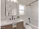 Modern bathroom with a single sink vanity, black hardware, and a shower-tub combo with black fixtures at 2339 W Ponderosa Ln, Phoenix, AZ 85023