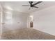 A carpeted bedroom features a ceiling fan, white walls, a closet, and an attached bathroom at 2339 W Ponderosa Ln, Phoenix, AZ 85023