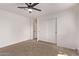 A carpeted bedroom offers a modern ceiling fan, white walls, and a closet at 2339 W Ponderosa Ln, Phoenix, AZ 85023
